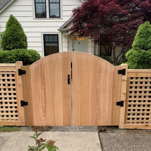 Custom arched cedar double gate with black hardware in Bellevue